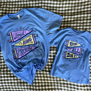 Two blue t-shirts with colorful graphics on a checkered fabric background